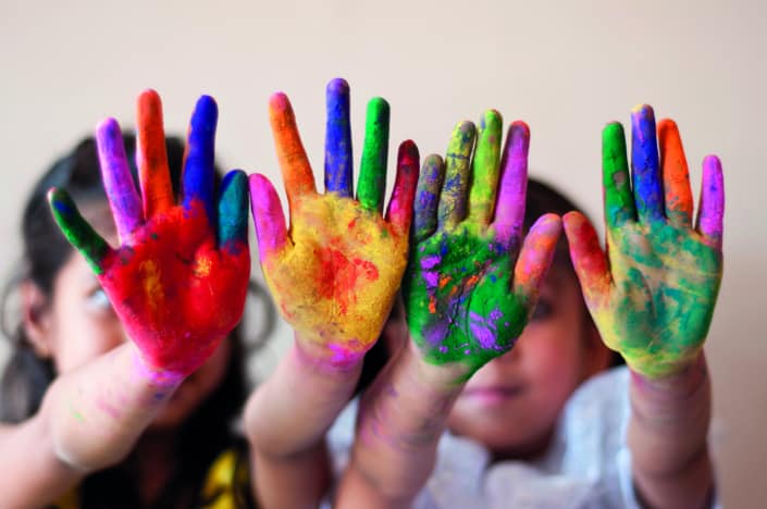 Two girls showing colorful painted hands