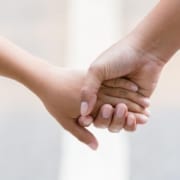 an adult holding a child's hand